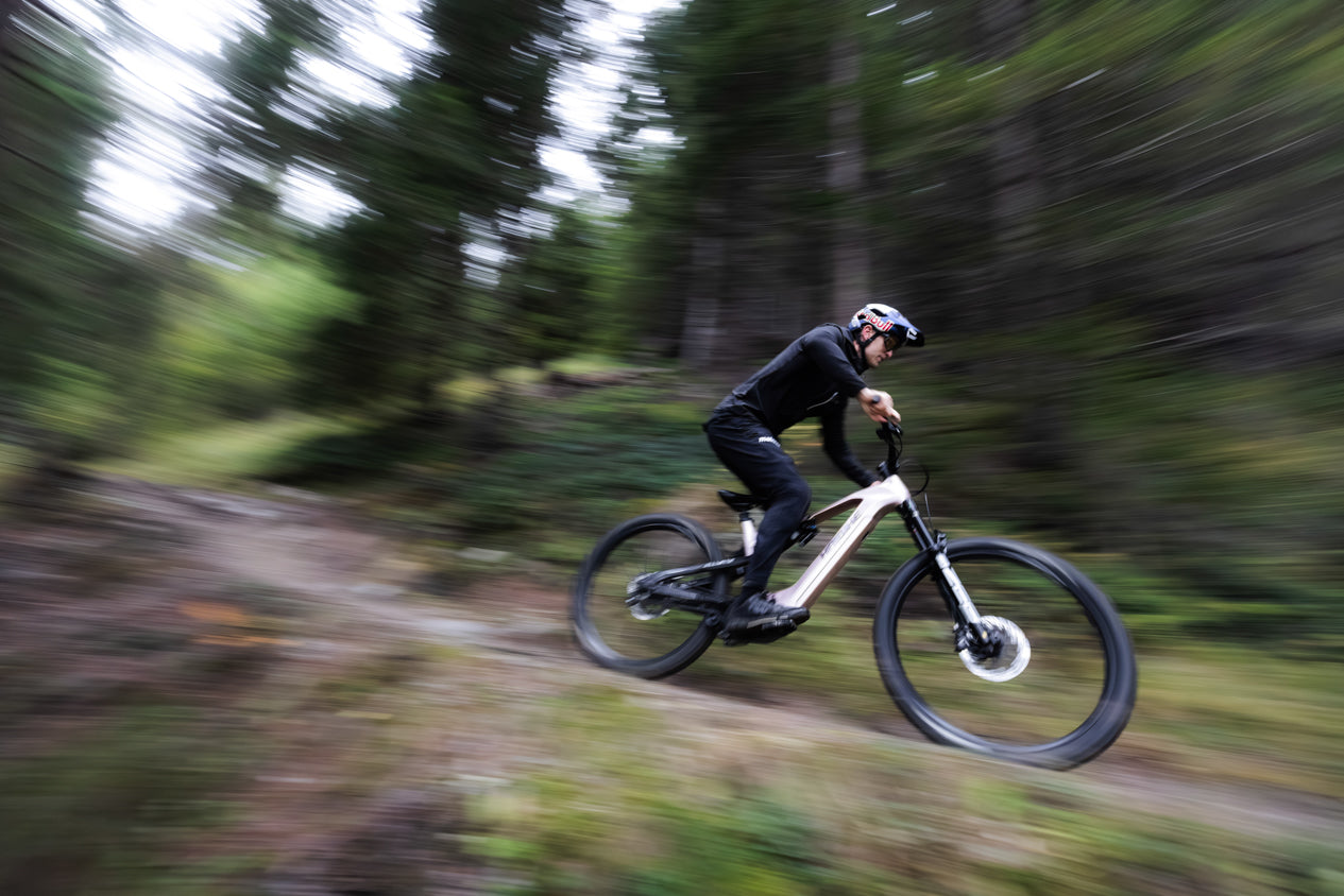 Rider speeding through a forest trail on a Haibike eBike with motion blur.