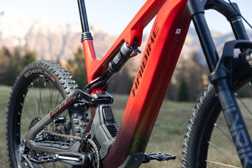 Haibike electric mountain bike close-up showing red frame, Bosch motor, ALLMTN components and suspension in alpine outdoor setting