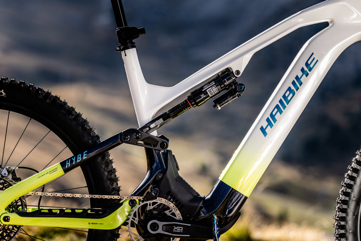 HAIBIKE HYBE CF11 rear suspension detail with RockShox rear shock, Bosch motor, SRAM XO drivetrain on neon yellow and black carbon frame